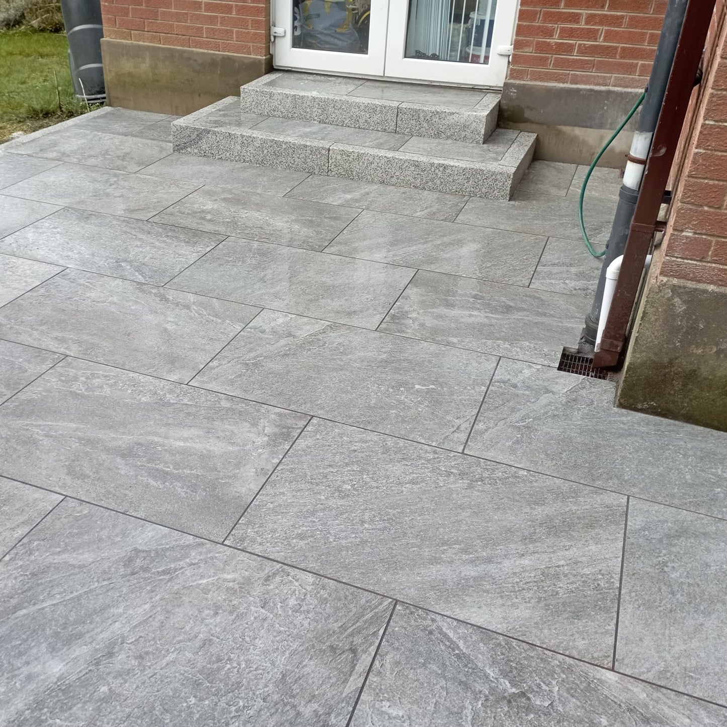 Patio area with steps featuring Dark Twice Qz Range Porcelain Paving Tiles in 900 x 600 x 20mm size. 