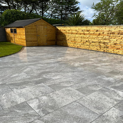 Large patio with garden shed and wooden fence. Paving is Dark Twice Qz Range Porcelain Paving Tiles. 