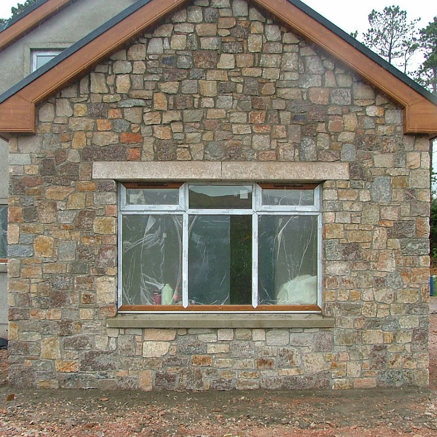 New build house with stone facade completed in Donegal Granite walling stone and gold granite lintels. 