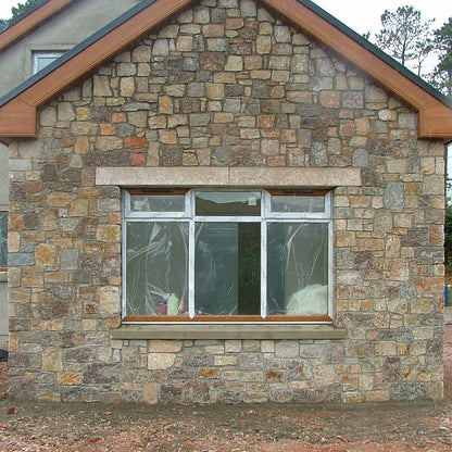 New build house with stone facade completed in Donegal Granite walling stone and gold granite lintels. 