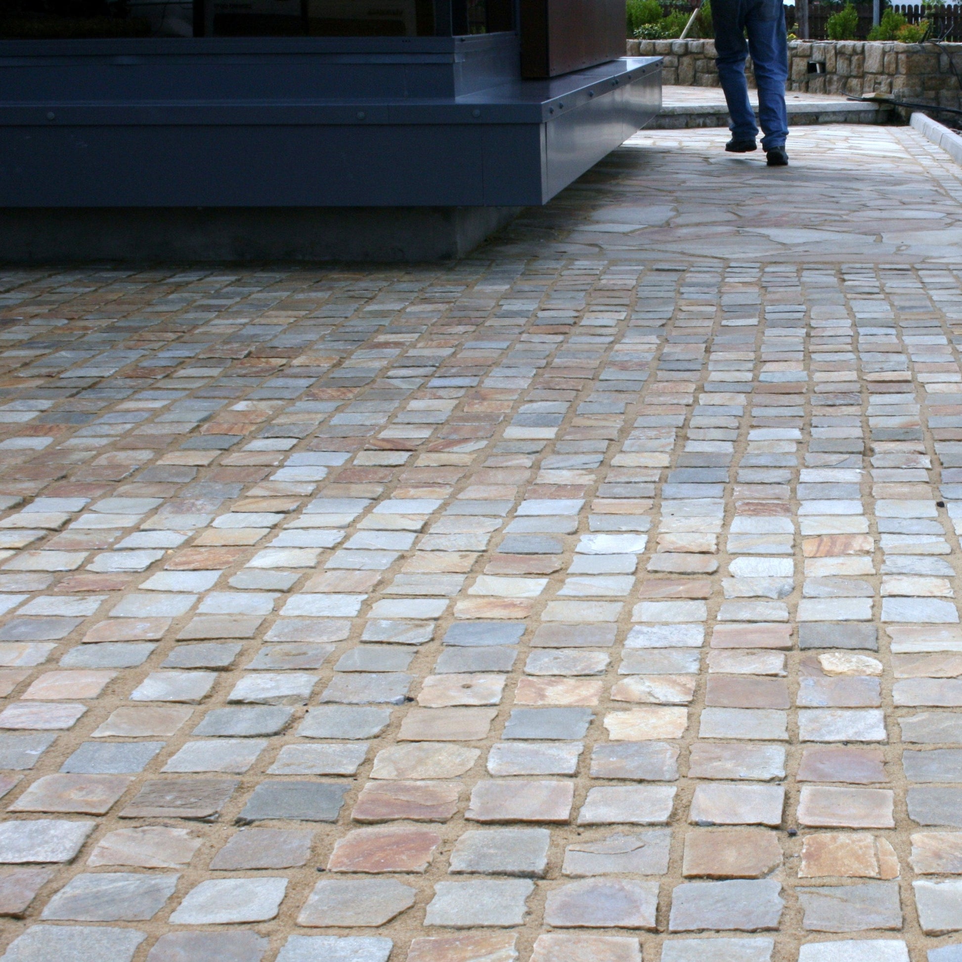Patio area completed using Donegal Quartzite Cobbles in 100 x 100mm size and Donegal Quartzite Crazy paving in a pathway in the background. 