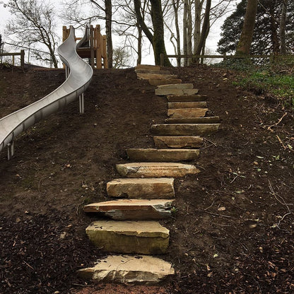 Donegal Quartzite Garden Steps leading up to a playground slide with trees in the background