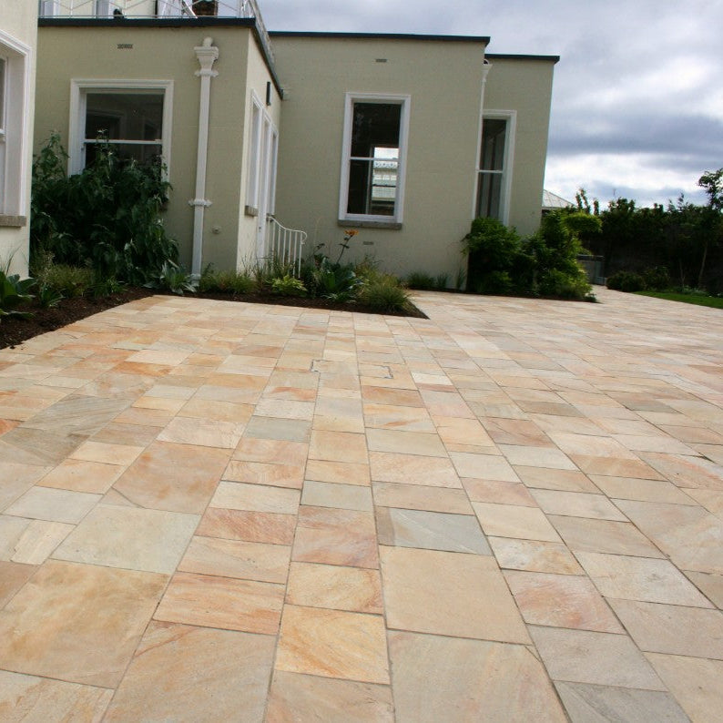 Large patio area with greenery finished in Donegal Quartzite Sawn Paving. 