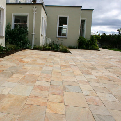 Large patio area with greenery finished in Donegal Quartzite Sawn Paving. 