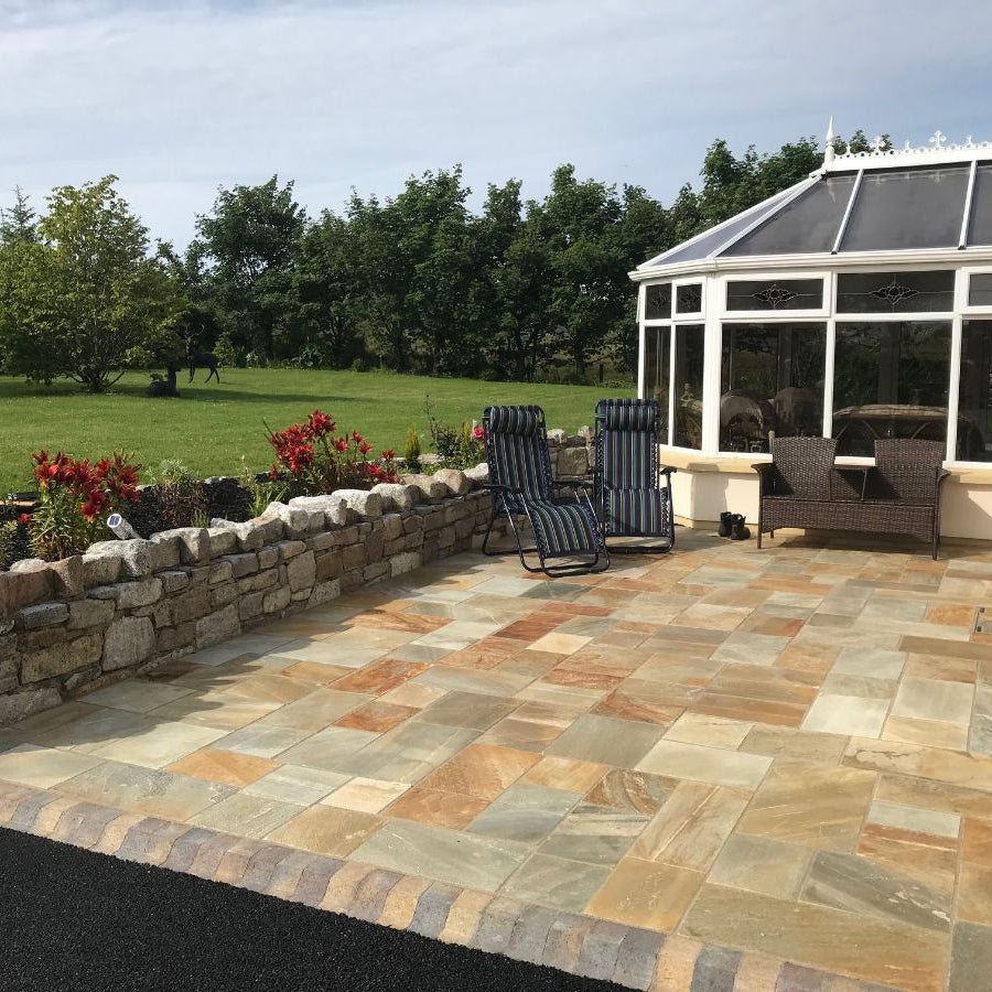 Patio area finished in Dongeal Quartzite Sawn Paving with well maintained garden. 