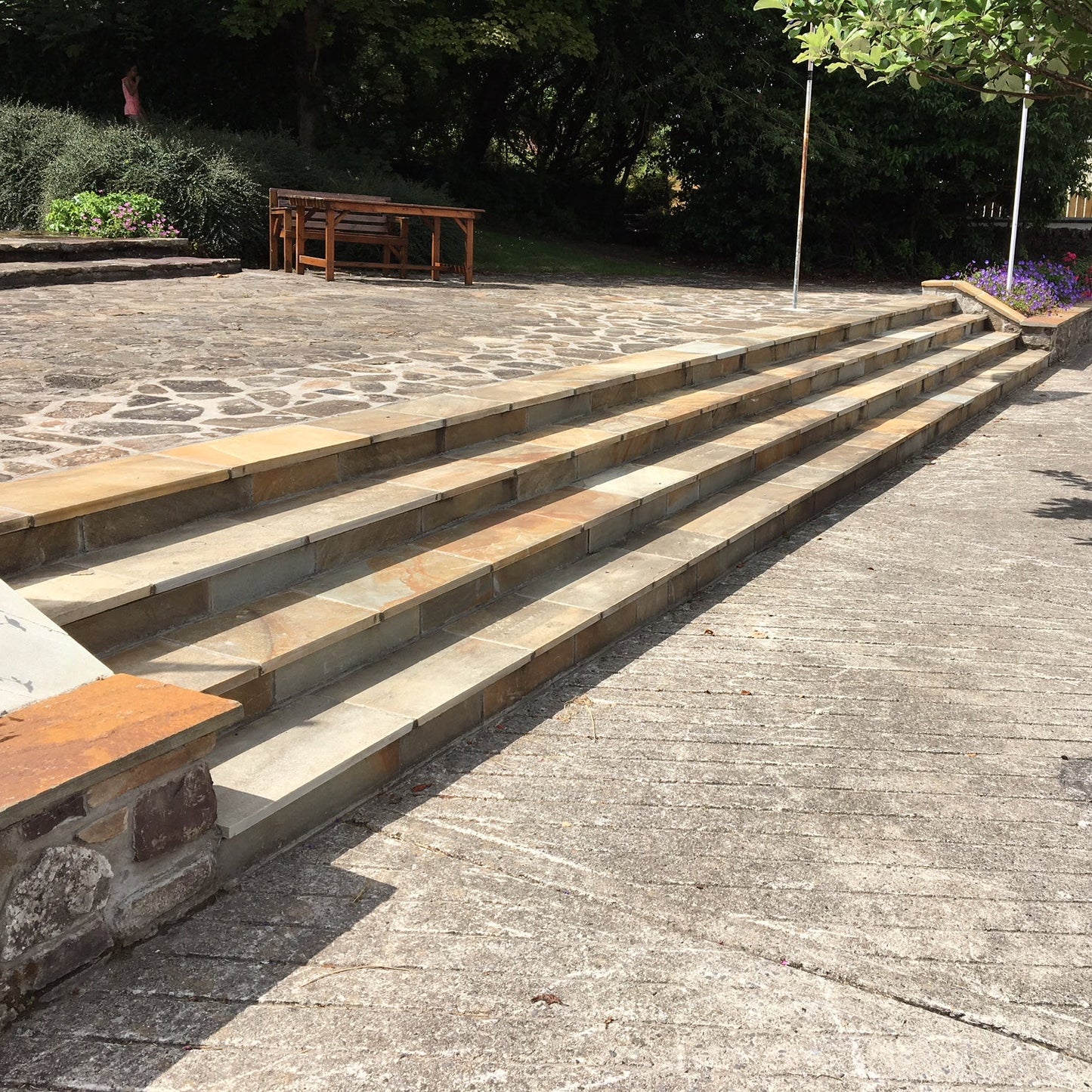 Bespoke Donegal Quartzite Stone Steps in a public area leading up to a raised patio. 