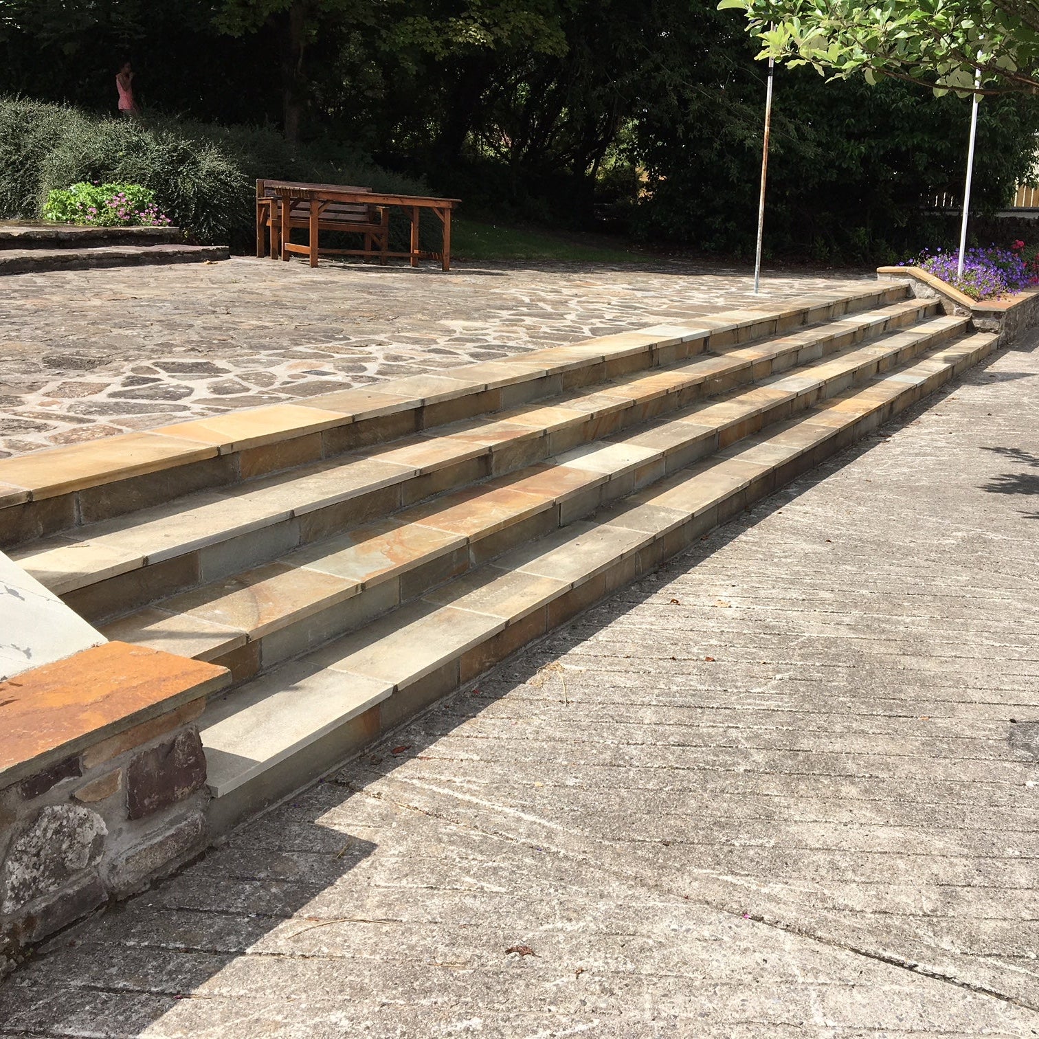 Bespoke Donegal Quartzite Stone Steps in a public area leading up to a raised patio. 