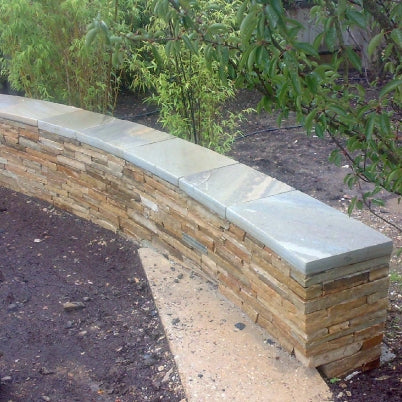 Stone wall with Donegal Quartzite Wall Capping in a garden setting