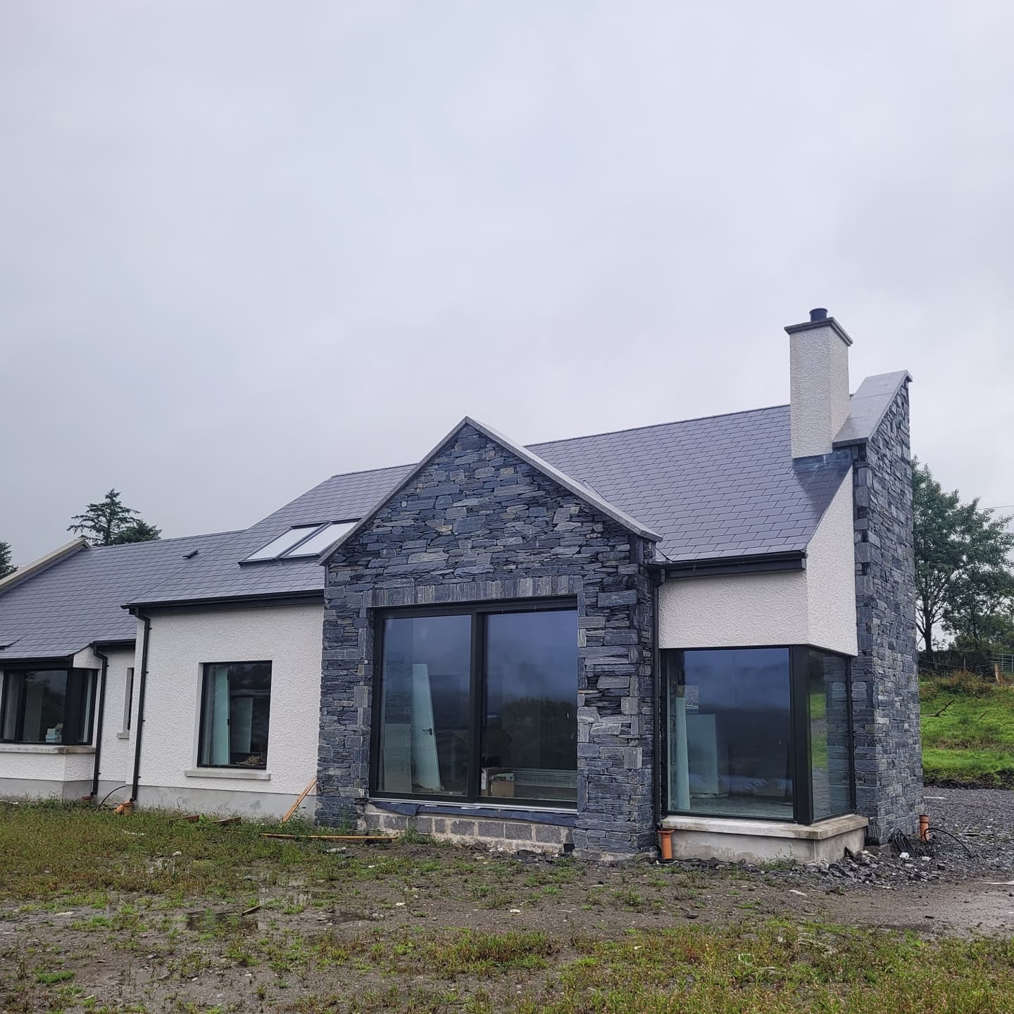 Modern house with Donegal Slate Rubble stone façade on a cloudy day