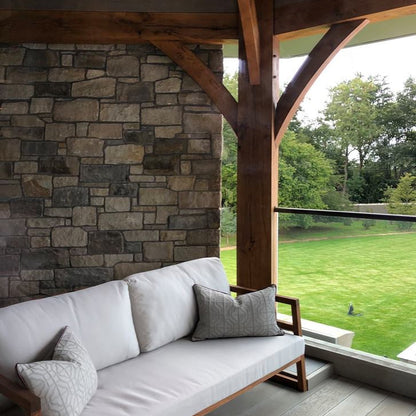 Balcony area with Dunhill Blend Machined walling stone behind a patio sofa. 