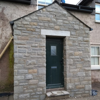 Small stone porch with a green door. Stone is Dust Grey Sandstone. 