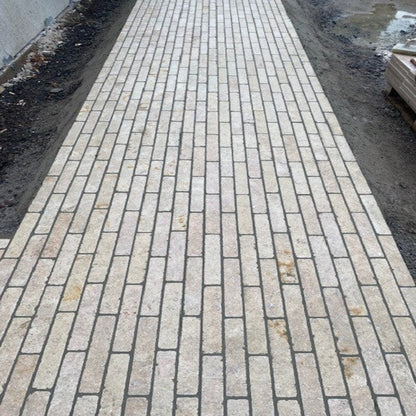 A pathway laid out with Egyptian limestone setts in a natural beige colour.