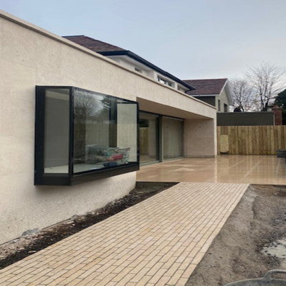 A set of elongated, smooth Egyptian limestone setts arranged on a tiled pathway in a landscaped outdoor area with a modern house in the background.