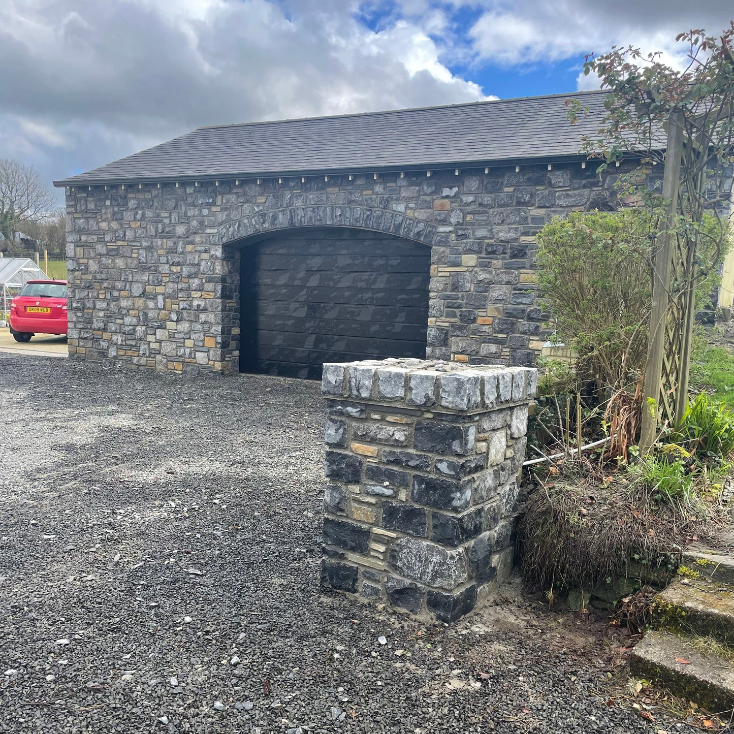 Another angle of the stone garage and a stone pillar in Fieldstone Blend Tumbled stone walling.