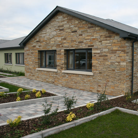 Modern house with stone facade and well-maintained garden