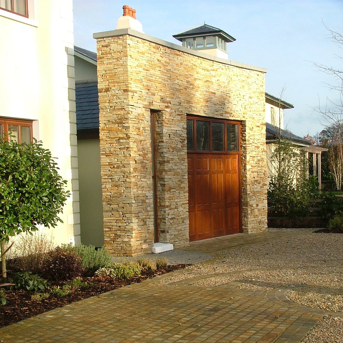 Donegal Quartzite cobbled driveway leading to a stone-built garage completed in Gold Donegal Quartzite Garden Walling.  