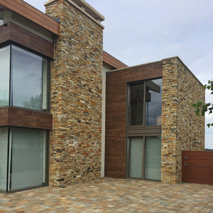 Modern house exterior with stone façade in our Gold Donegal Quartzite Garden Walling and Donegal Quartzite cobbled patio area.