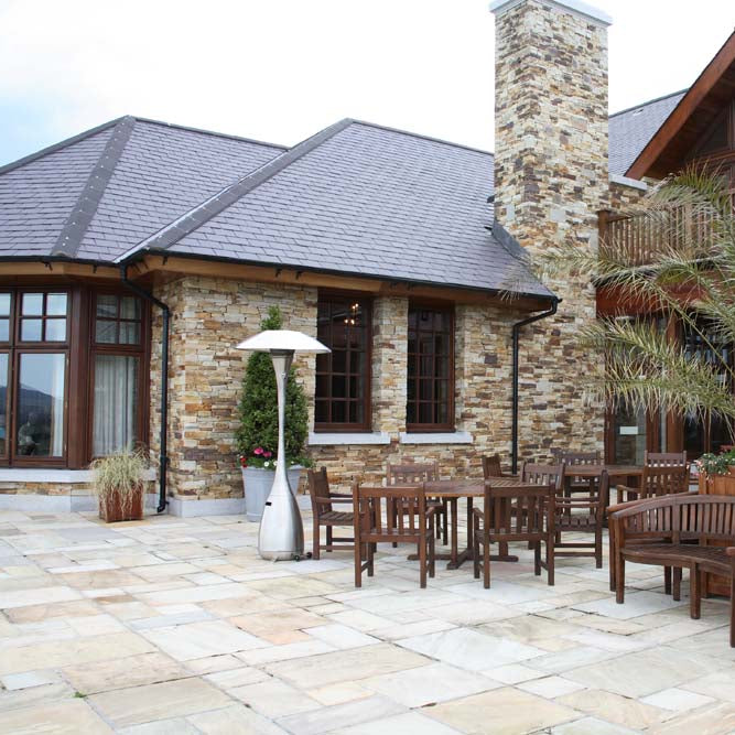 Outdoor patio area with a feature wall built in Gold Donegal Quartzite Machined. 