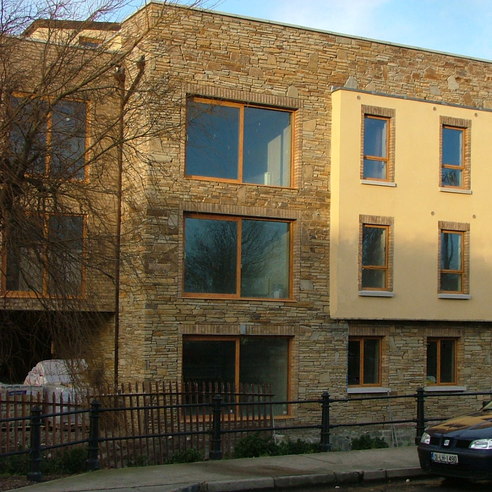 Modern building with stone facade completed using our Gold Donegal Quartzite Random Rubble and glass windows. 