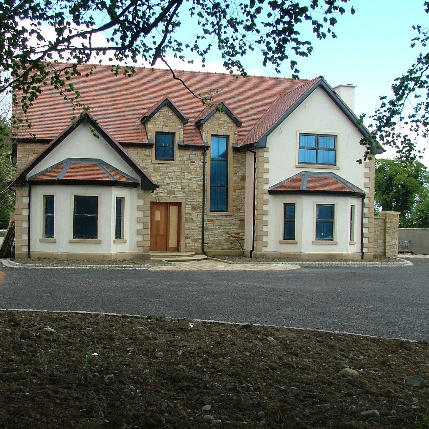 New build completed using Gold Donegal Quartzite Random Rubble walling stone and architectural sandstone window and door surrounds.  