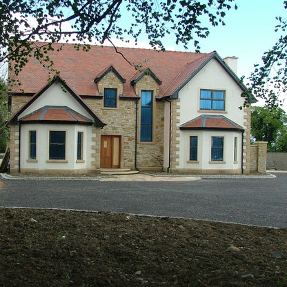 New build completed using Gold Donegal Quartzite Random Rubble walling stone and architectural sandstone window and door surrounds.  