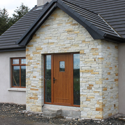 House exterior with stone facade and wooden door. Stonework is Gold Donegal Quartzite Stoneer Cladding.