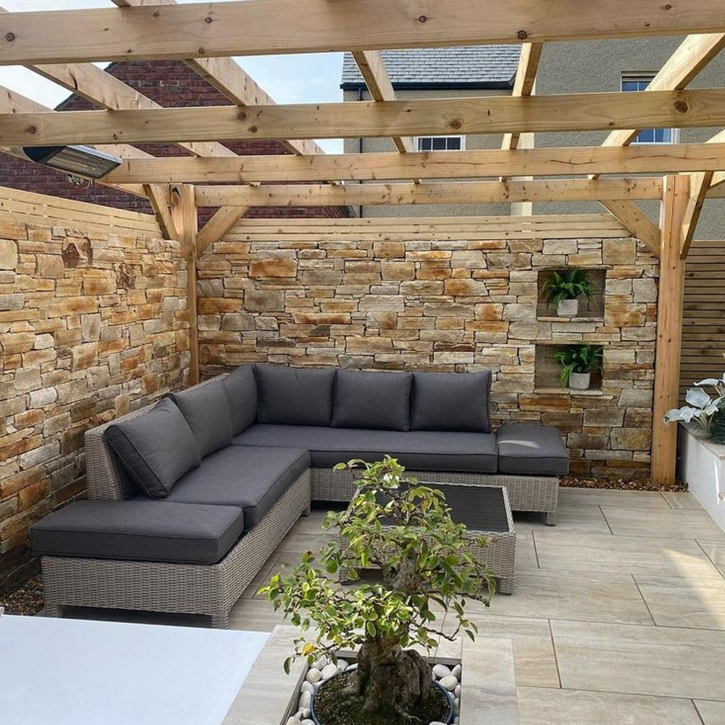 Outdoor patio area with natural stone feature wall in Gold Donegal Quartzite Stoneer Cladding. 