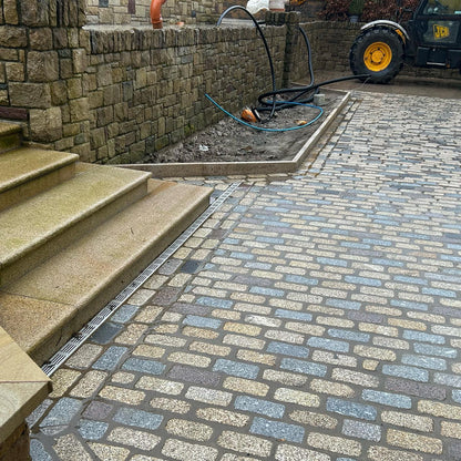 Paved area with Gold Granite steps and a garden hose in the background