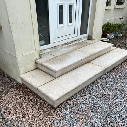 Gold Granite Steps leading to a white front door. 