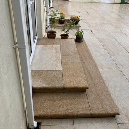 Outdoor patio area with Gold Granite steps leading to a house entrance