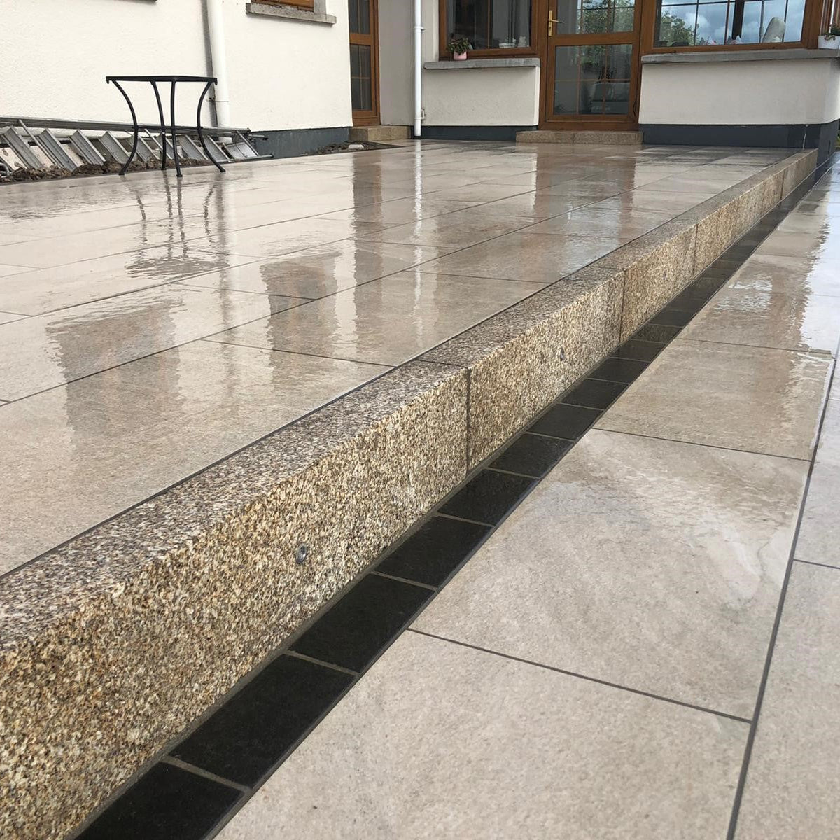 Porcelain patio featuring Gold Granite Kerbing. 