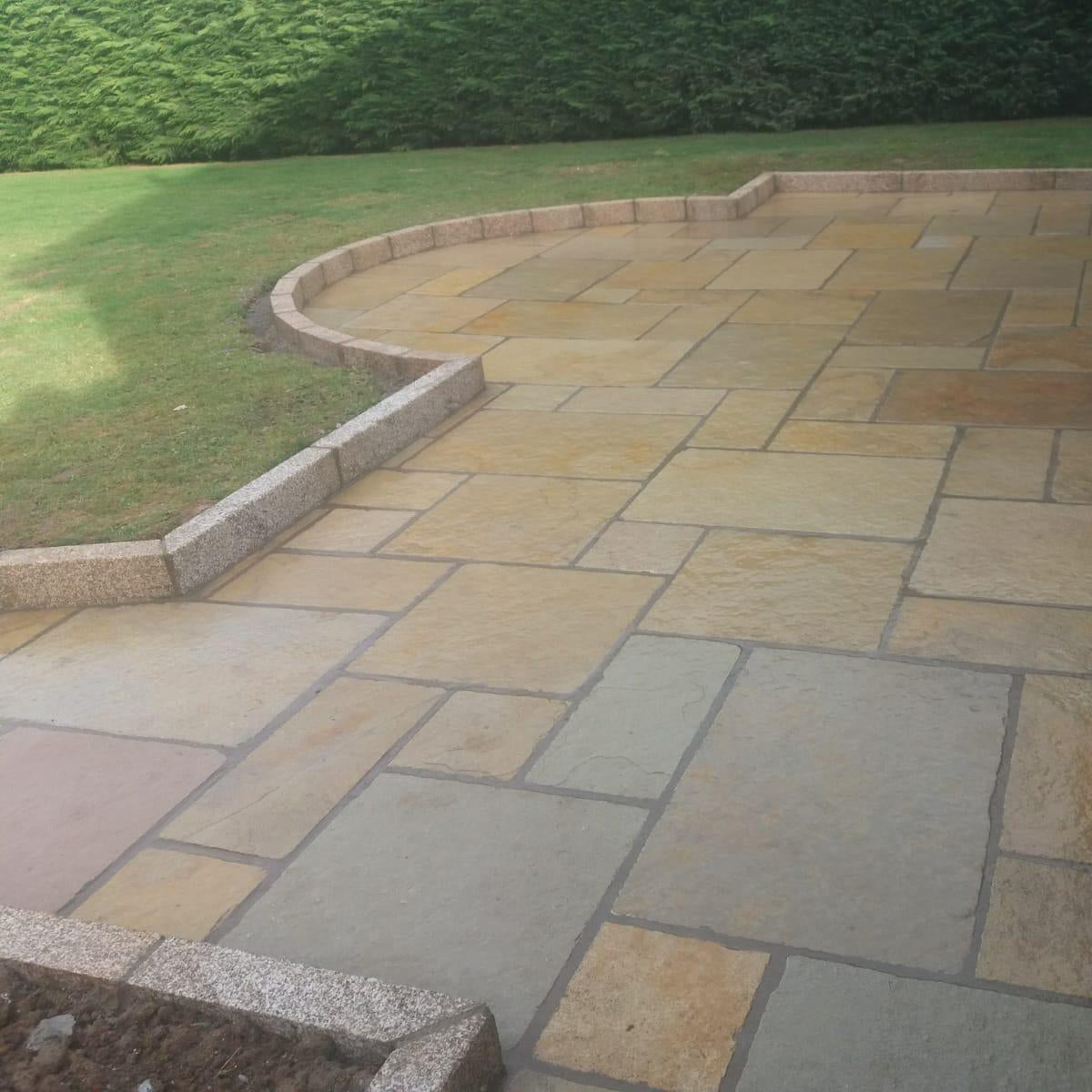 Patio area featuring garden edging in Gold Granite Kerbing with a bush hammered finish. 