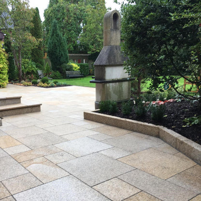 Patio area with Gold Granite Kerbing with garden and trees in the background.
