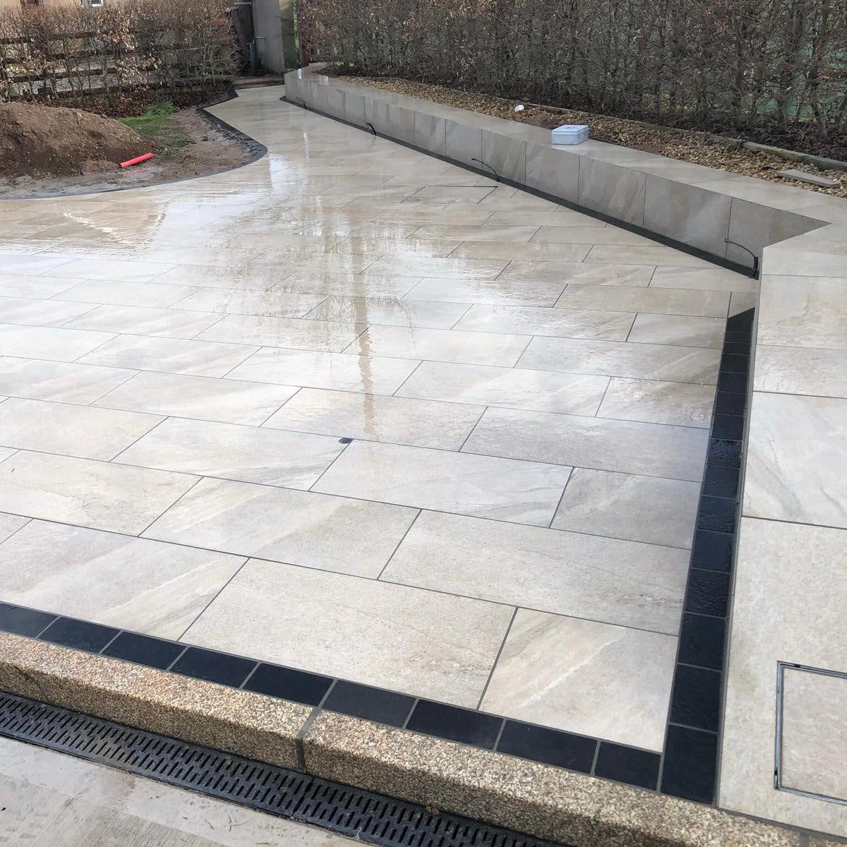 Porcelain patio under construction. Design features Gold Granite Kerbing. 