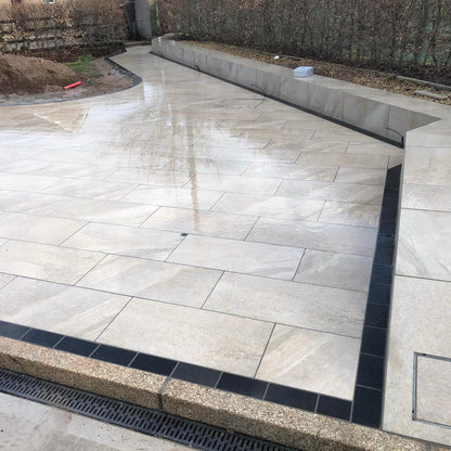Porcelain patio under construction. Design features Gold Granite Kerbing. 