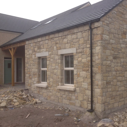 Stone building under construction with bespoke Gold Granite Window lintels and siils. 