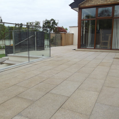Patio area with glass balustrade featuring Gold Granite Paving in 600 x 300mm 