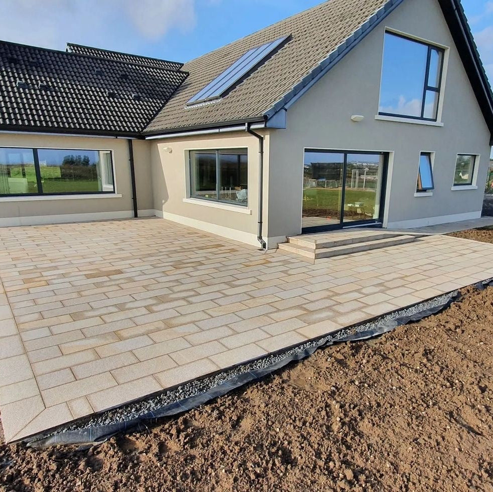 Patio area completed using Gold Granite Paving in 600 x 300mm size. Garden under construction. 