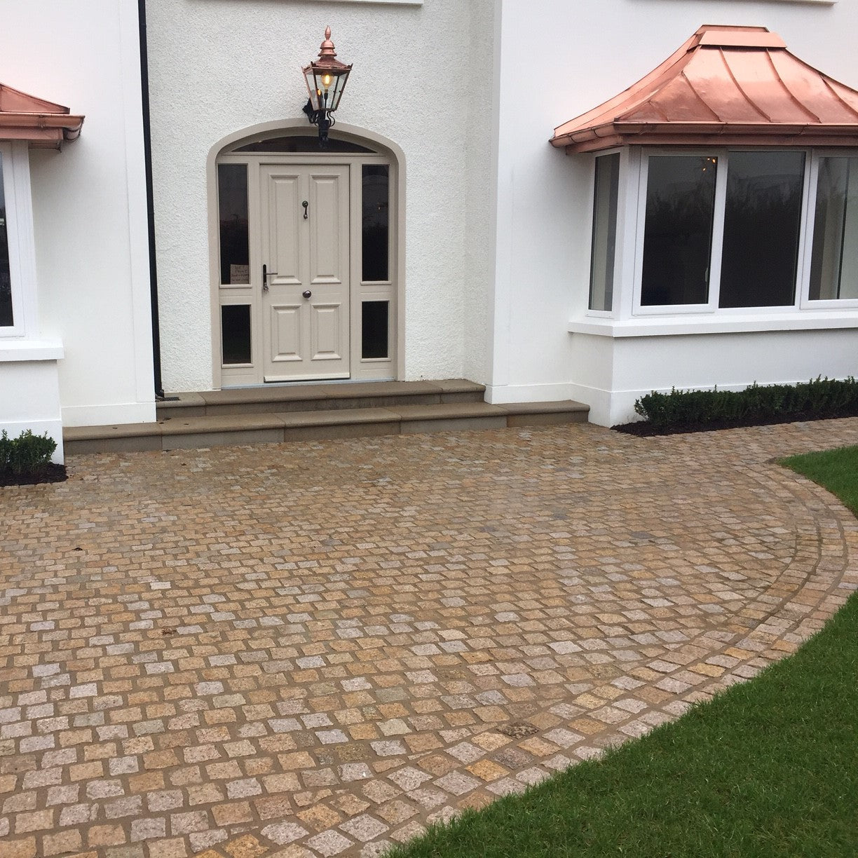 Pathway showcasing Gold Granite Cobbles leading towards house entrance. 