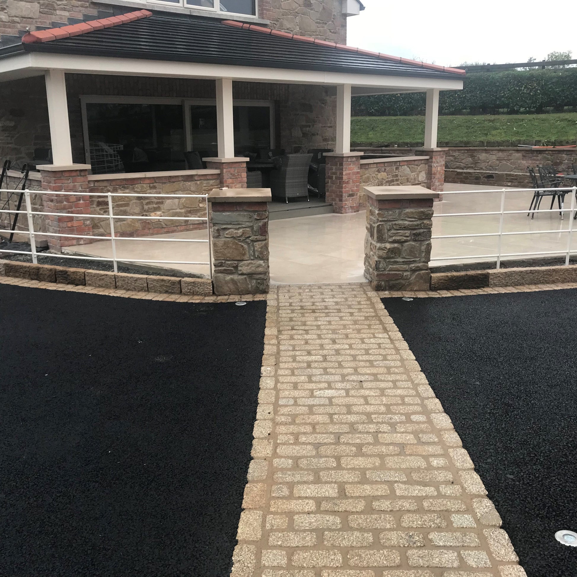 Tarmac driveway with natural stone pathway completed using Gold Granite Cobbles in 200 x 100mm size. 