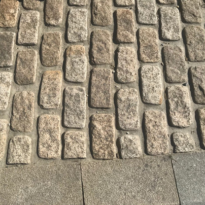 Close up of Gold Granite Paving Cobbles with a bush hammered and lightly tumbled finish. 