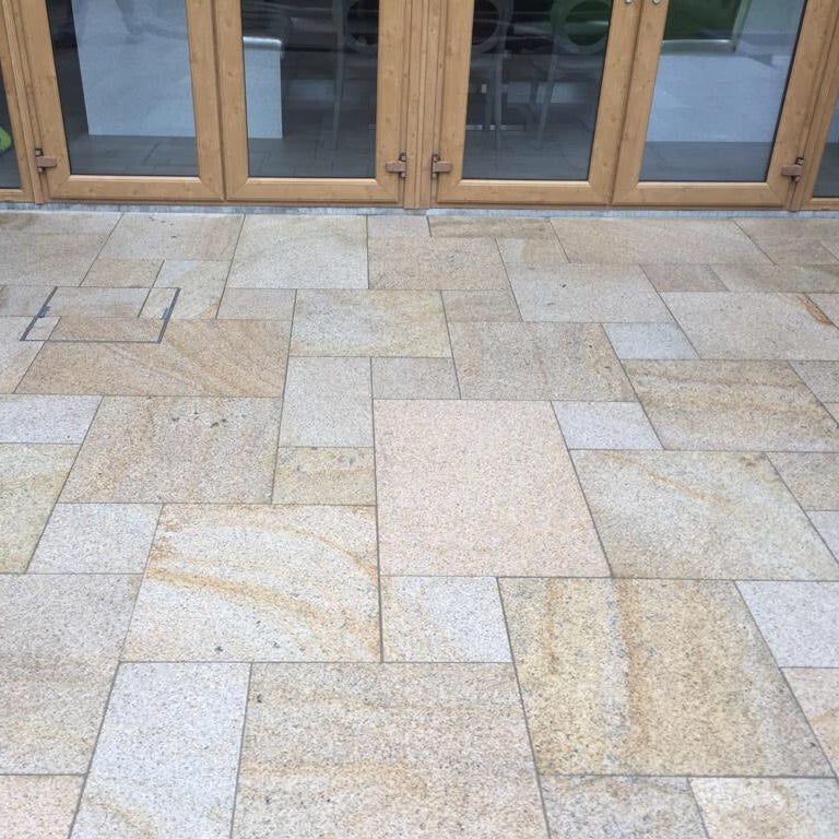 Close up of Bush Hammered Gold Granite Paving in mixed patio pack sizes. 