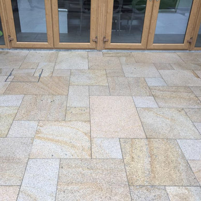 Close up of Bush Hammered Gold Granite Paving in mixed patio pack sizes. 