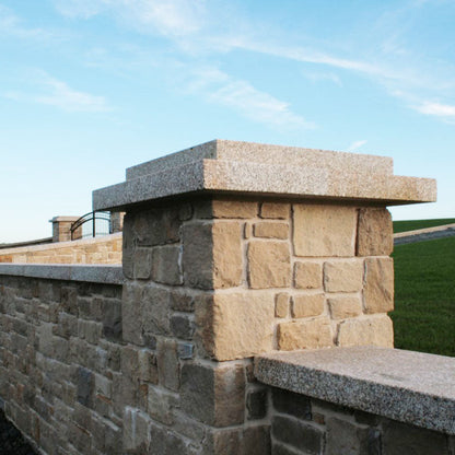 Sandstone wall with bespoke Gold Granite Pillar and Wall Capping.