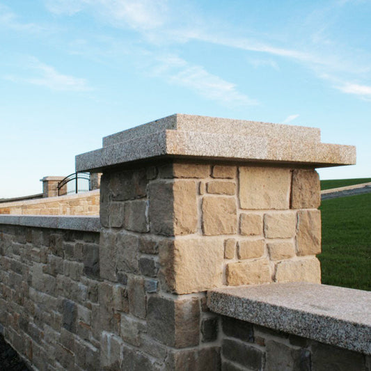Sandstone wall with bespoke Gold Granite Pillar and Wall Capping.