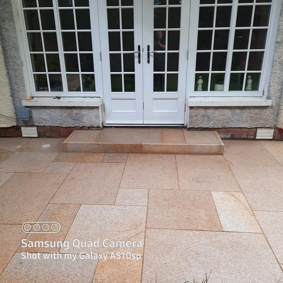 Patio doors leading out on to a Gold Granite patio and step finished using Gold Granite Pin Kerbs. 