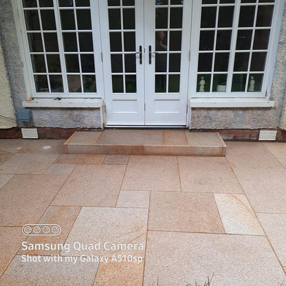 Patio doors leading out on to a Gold Granite patio and step finished using Gold Granite Pin Kerbs. 