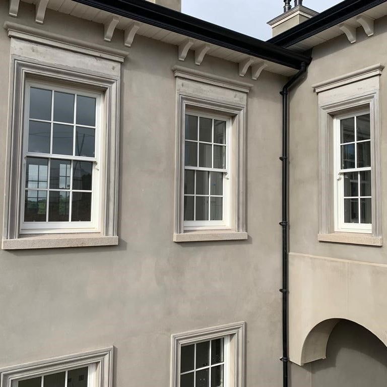 Façade of a building with multiple windows with bespoke Gold Granite Sills. 