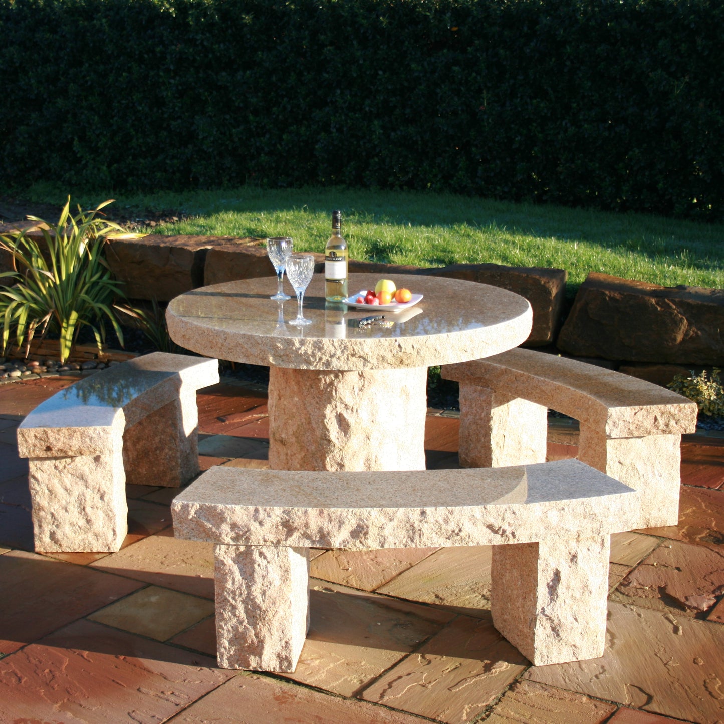 Gold Granite Stone outdoor table with benches in a garden setting