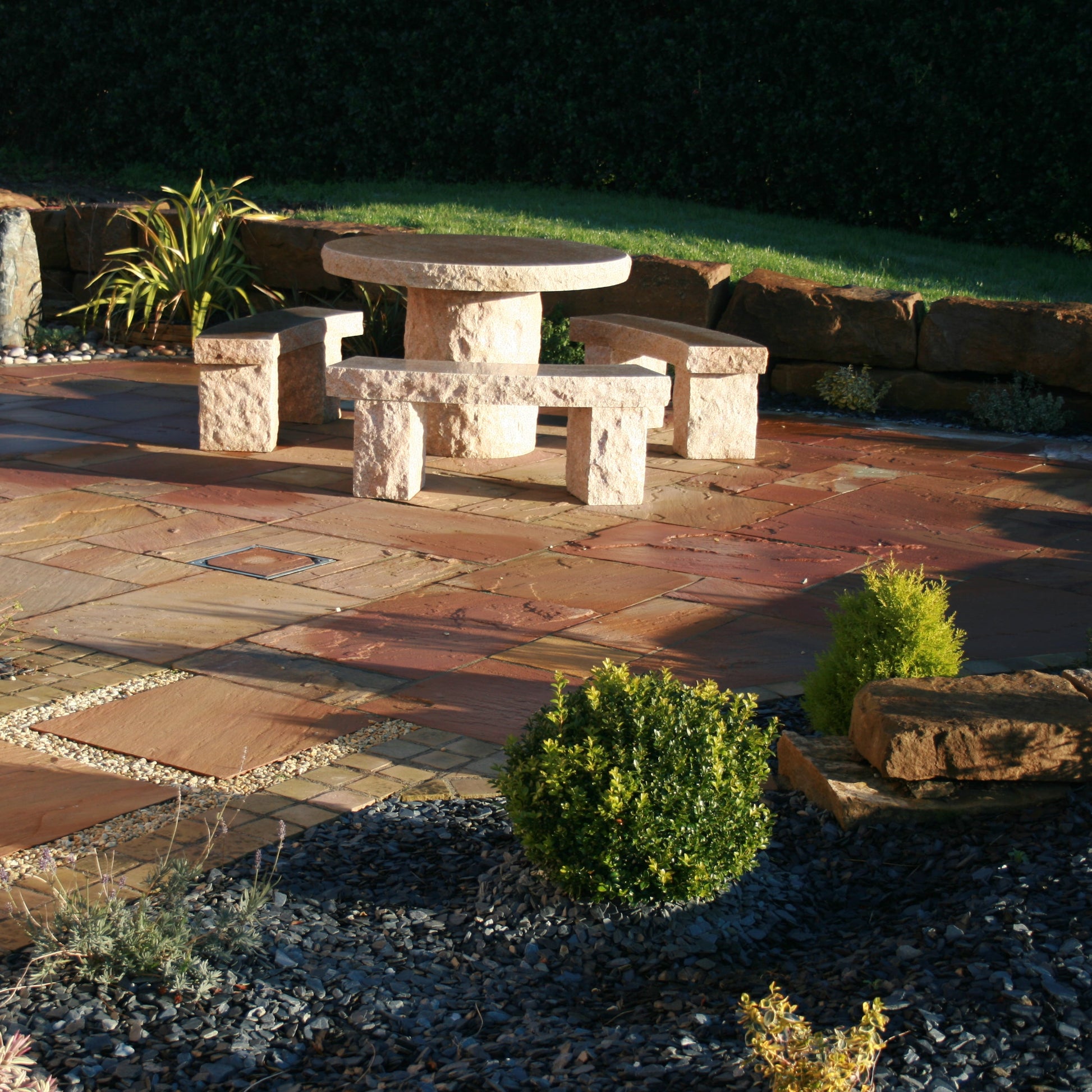 Garden patio area featuring a Gold Granite Table & Bench Set. 